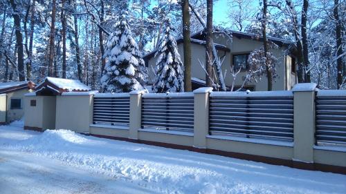 a house with a fence covered in snow at Villa Podkowa in Podkowa Leśna