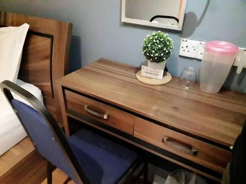 a wooden desk with a potted plant on it next to a bed at My Home Hotel Wangsa Maju in Kuala Lumpur