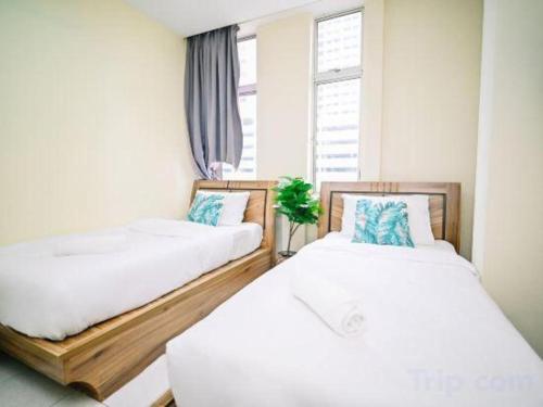 two beds in a room with a window at My Home Hotel Wangsa Maju in Kuala Lumpur
