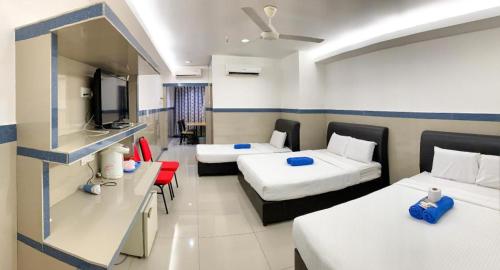 una camera d'albergo con due letti e una televisione di Burmahtel Hotel a George Town