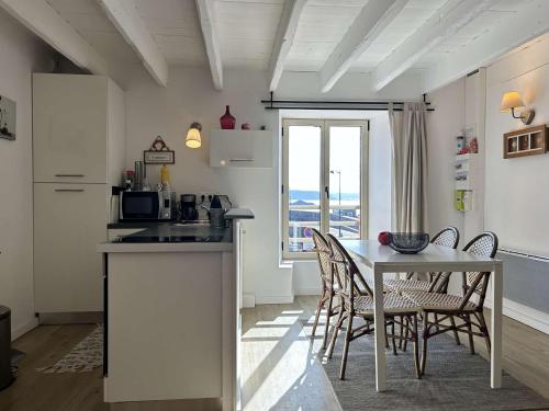 une cuisine et une salle à manger avec une table et des chaises dans l'établissement Appartement duplex 46m2 sur le port d'Erquy, à Erquy