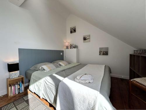 une chambre avec un grand lit dans un grenier dans l'établissement Appartement duplex 46m2 sur le port d'Erquy, à Erquy