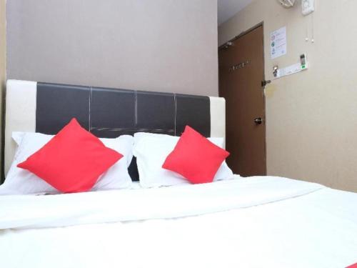 a bed with three red pillows on it at OYO 44123 Hotel Al-Saif in Kuala Kerai