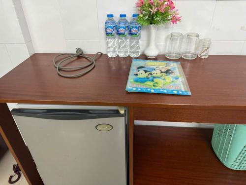 a wooden desk with a counter top with a mickey mouse book at Khách sạn Tường Minh - Tuong Minh Hotel in Cao Lãnh