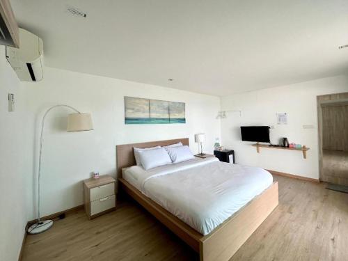 a bedroom with a large bed and a tv at Rockbund Fishing Chalet in Kampong Batu Gajah