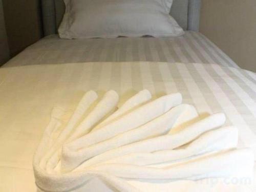 a pile of white towels sitting on a bed at OYO 89780 Lodge 37 in Ranau