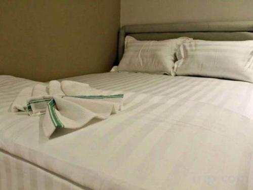 a white bed with white sheets and pillows at OYO 89780 Lodge 37 in Ranau