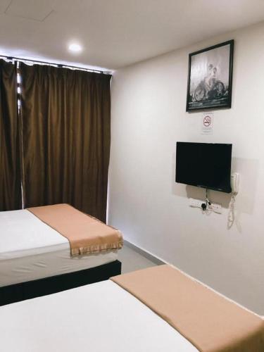 a room with two beds and a flat screen tv at Power Hotel in Georgetown