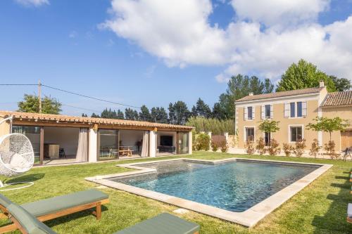 une cour arrière avec une piscine et une maison dans l'établissement Le Champ des Cigales, à Noves