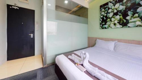 a bedroom with a bed and a painting of flowers at Kimal Hotel Taiping in Taiping