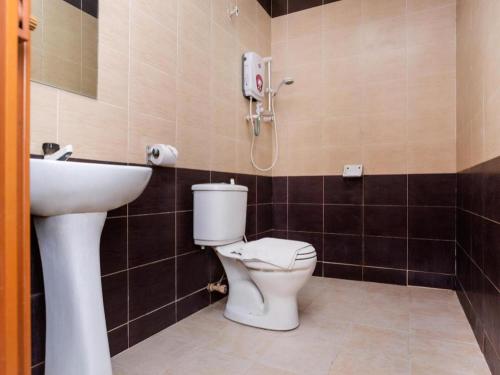 a bathroom with a toilet and a sink at Super OYO 1114 Neo Pegasus Hotel in Segamat