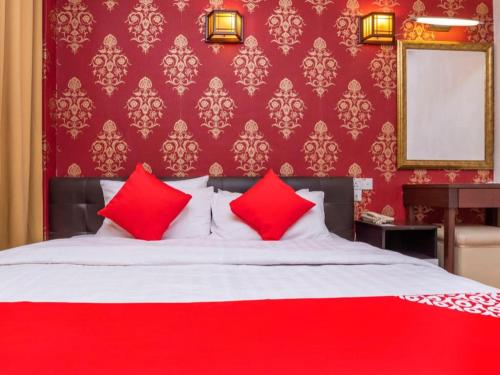 a red bed with two red pillows in a room at Super OYO 1114 Neo Pegasus Hotel in Segamat