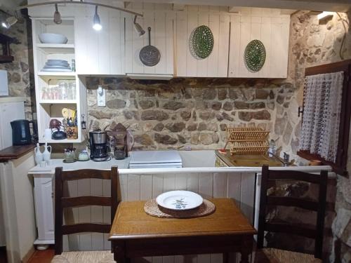 - une cuisine avec une table en bois et un comptoir dans l'établissement Le refuge, à Arles