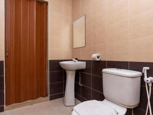 a bathroom with a toilet and a sink at Super OYO 1114 Neo Pegasus Hotel in Segamat