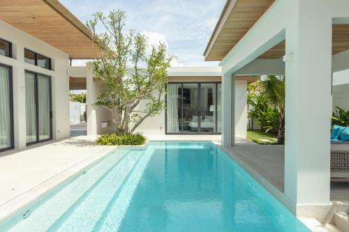 an infinity pool in the backyard of a house at Mouana Breeze Maikhao VIP 4-bedroom Pool Villa 9915 in Mai Khao Beach