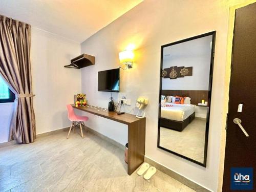 a hotel room with a desk and a mirror at Well Hotel by UHA in Johor Bahru