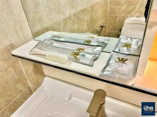 a bathroom with a counter with towels and a sink at Well Hotel by UHA in Johor Bahru