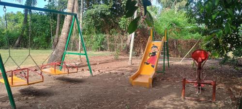a playground with several swings and a slide at amee's retreat in Diveagar