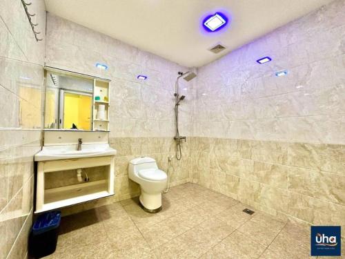 a bathroom with a toilet and a sink and a mirror at Well Hotel by UHA in Johor Bahru