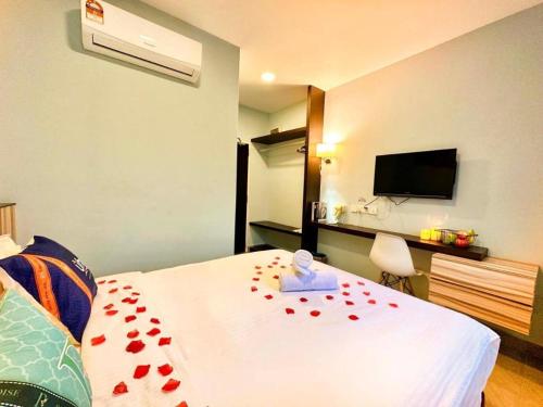 a bedroom with a bed with red rose petals on it at Well Hotel by UHA in Johor Bahru