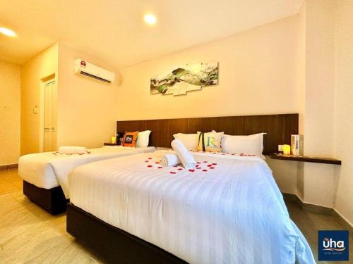 a hotel room with two beds with roses on them at Well Hotel by UHA in Johor Bahru