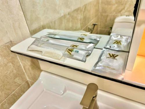a bathroom with a counter with towels and a mirror at Well Hotel by UHA in Johor Bahru