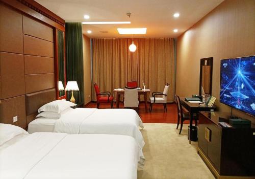 a hotel room with two beds and a flat screen tv at OSOTTO RECREATION HOTEL in Foshan