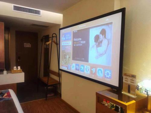 a large flat screen tv hanging on a wall at James Joyce Coffetel·Shijiazhuang Economic and Technological Development Zone Chuangye Road in Shijiazhuang
