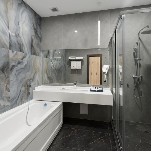 a bathroom with a tub and a sink and a shower at Tauke Khan Plaza in Shymkent