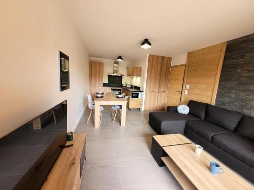 un salon avec un canapé et une table dans l'établissement Résidence Cottage Alpin - Appartement 4 personnes au calme MAE-0801, aux Gets