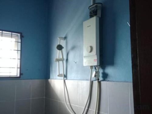 a bathroom with a shower in a blue wall at OYO HOME 90691 A4 Homestay in Bubul