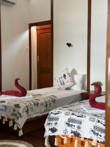 two beds in a room with red snakes on them at 3WILL Bunaken Dive Resort in Bunaken