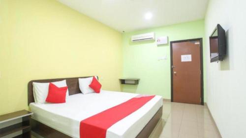 a hotel room with a bed with red pillows at HS Hotel Siswa Near UTAR in Kampar