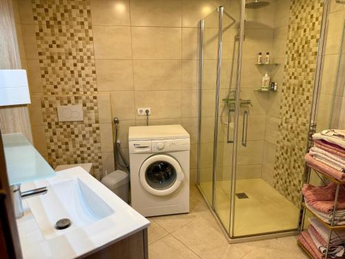y baño con lavadora y ducha. en Palmeras 15, en Nerja