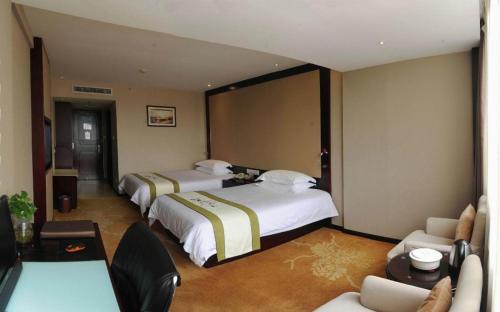 a hotel room with two beds and a couch at Quanzhou Overseas Chinese Hotel in Quanzhou
