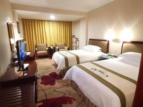 a hotel room with two beds and a television at Quanzhou Overseas Chinese Hotel in Quanzhou