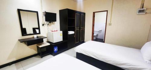 a hotel room with two beds and a mirror at Mark Four Place Hotel in Phrae
