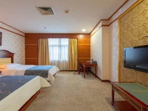 a hotel room with two beds and a flat screen tv at Chonpines Hotels·Zhongshan Xiaolan LRT Station in Zhongshan