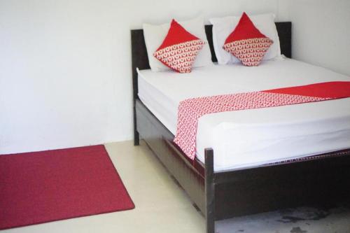 a bedroom with two beds with red and white pillows at OYO 93784 Kost Bu Eli Syariah in Malang