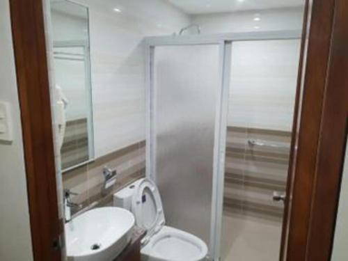a bathroom with a toilet and a sink at Hotel Fleur de Liz in Panglao