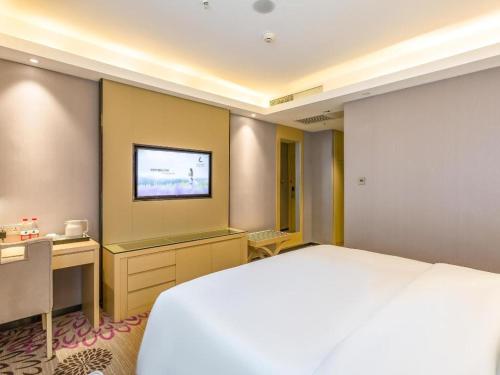 a bedroom with a bed and a desk and a television at Lavande Hotel Langfang Xianghe in Langfang