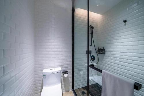 a white bathroom with a shower and a toilet at City Comfort Premier Hotel Xiaogan Anlu Railway Station Dongda Times Square in Xiaogan
