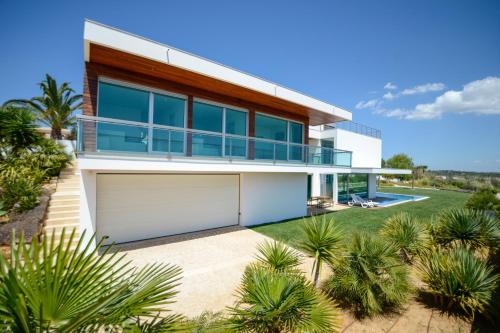 a house with a garage and palm trees at Palmares Beach, Golf & Dream in Lagos