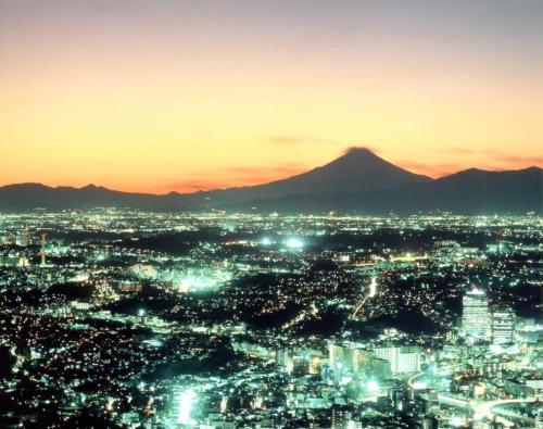 a view of a city at night with a mountain at Yokohama Royal Park Hotel in Yokohama