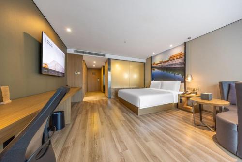 a hotel room with a bed and a flat screen tv at Atour Hotel Beijing West Railway Station South Square in Beijing