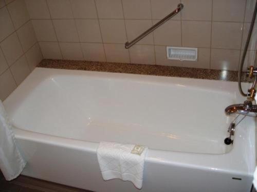 a white bath tub in a bathroom with a towel on it at Yokohama Royal Park Hotel in Yokohama