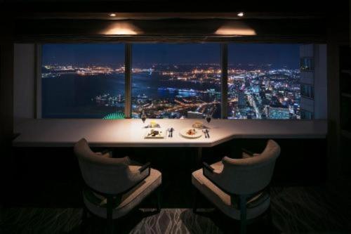 a bathroom with a window with a view of a city at Yokohama Royal Park Hotel in Yokohama