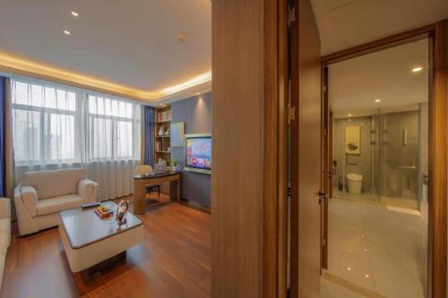 a living room with a couch and a table and a television at The Long Red Hotel Daye Huangshi in Huangshi