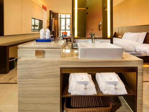 a bathroom with a sink and a bed at Zmax Hotel Guangzhou Railway Station in Guangzhou