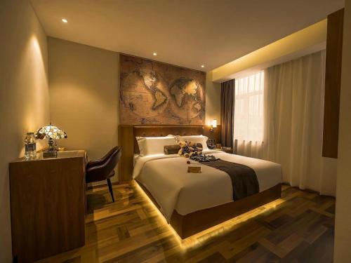 a hotel room with a large bed and a desk at James Joyce Coffetel Shenyang North Railway Station Qishan Road Metro Station in Shenyang